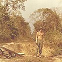 Scott Krueger with bombed out steel trestle bridge in background.  Road over his shoulder is in Cambodia.